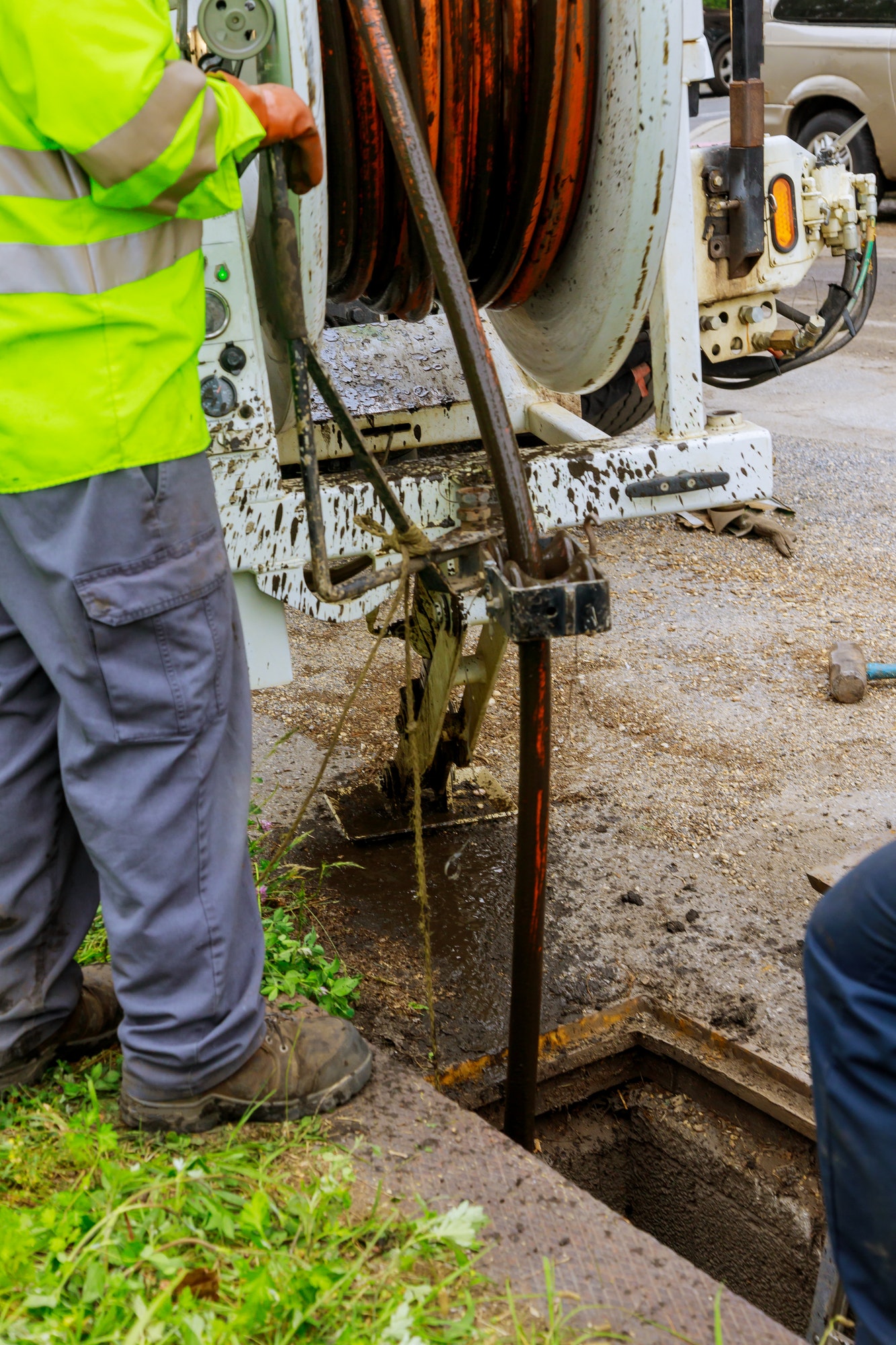 Sewage cleaning workers equipment with sewer on a town street on industrial truck